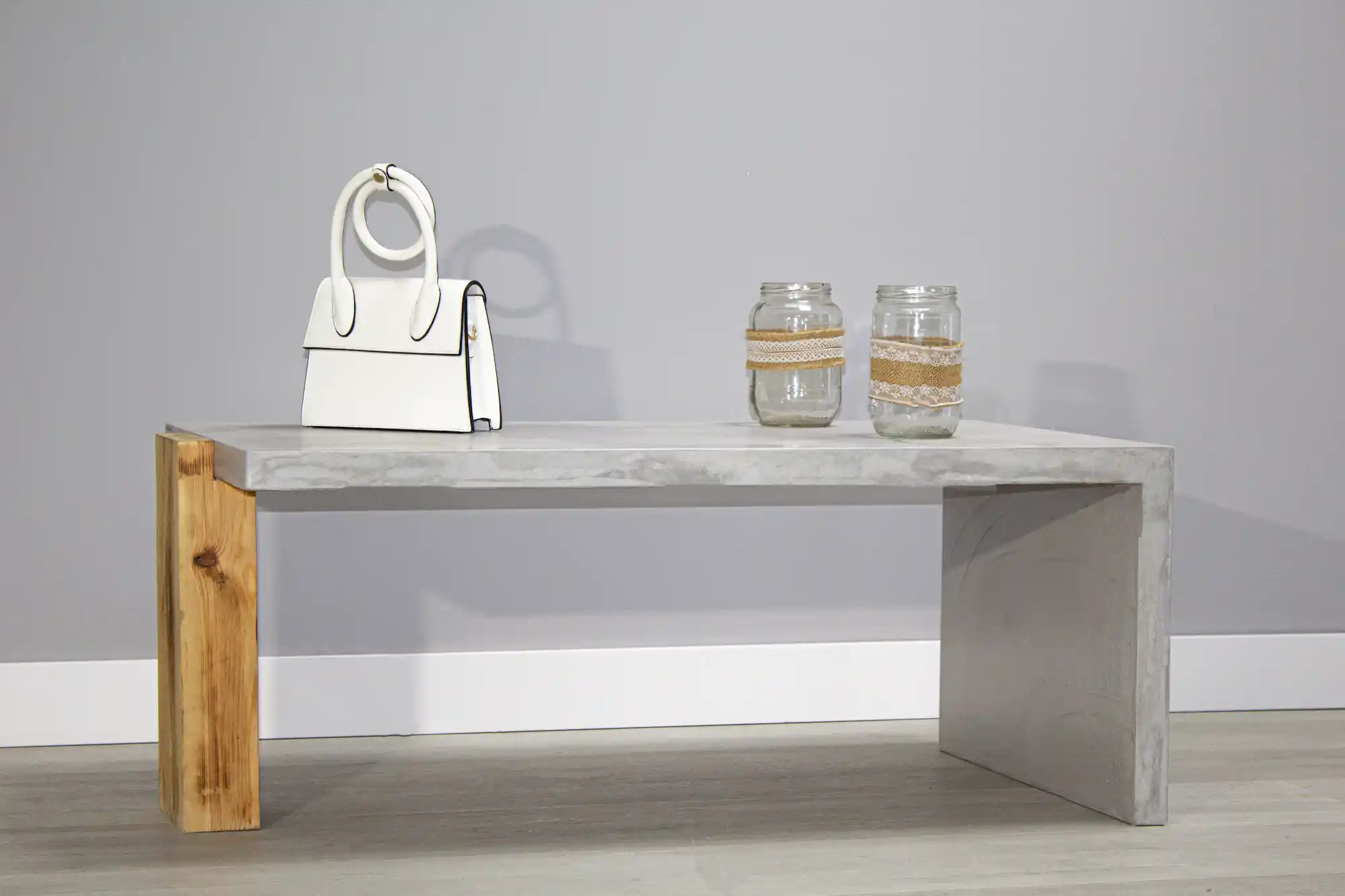 Mesa de microcemento gris con detalle en madera natural, vista frontal en ambiente neutro | Kretos